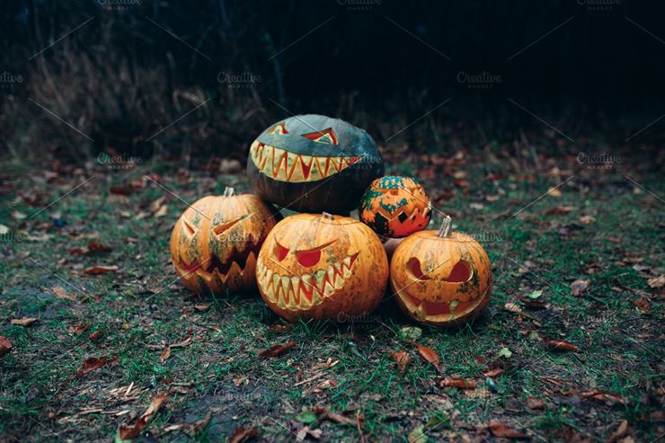 Group of Halloween Pumpkins with A Carved Face Lying On the Ground Web3Canvas